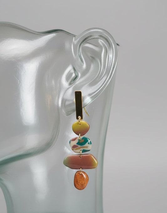 brass rectangular bar affixed to organic shaped stone shaped objects